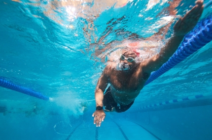 man swims in pool underwater