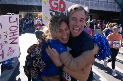 Marathon runner hugs someone in crowd at TCS NYC Marathon.