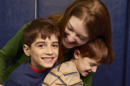 woman hugs 2 kids