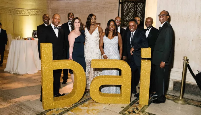 group gathered around bai sign