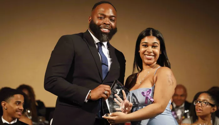 man and woman hold award