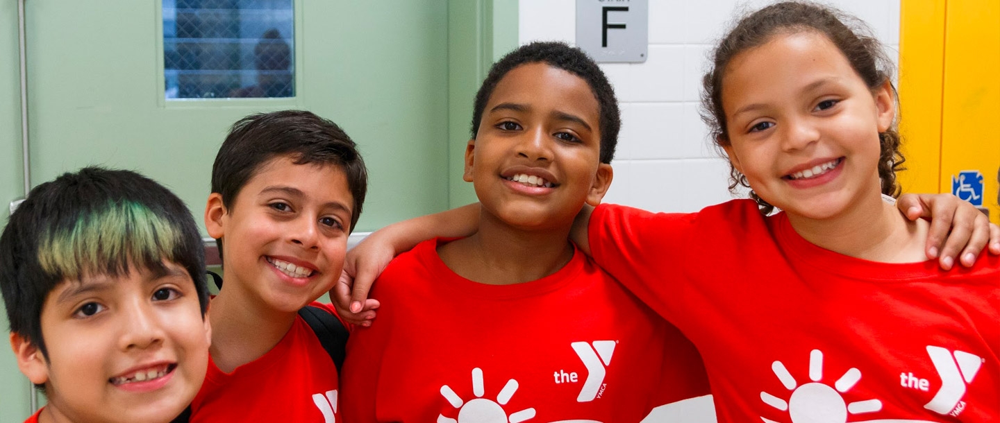 A group of smiling kids at the LIC YMCA summer day camp.