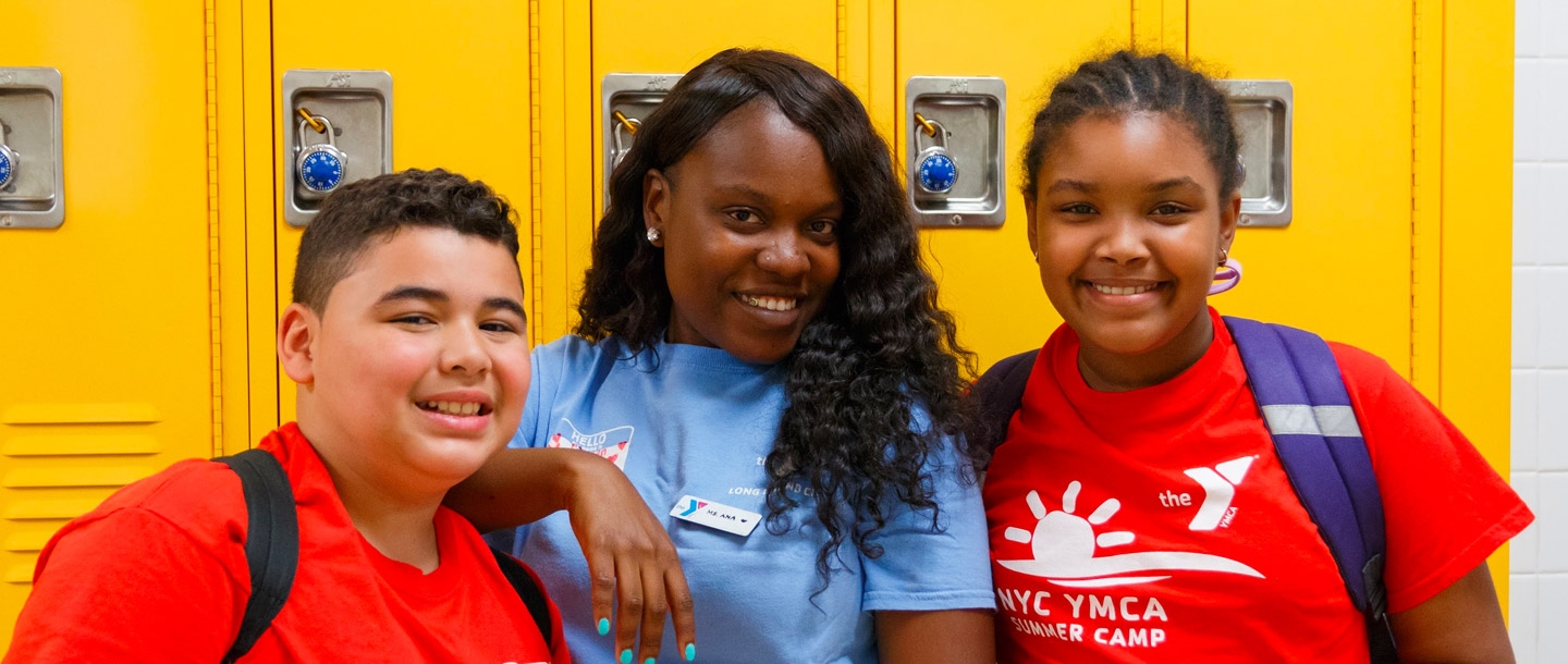 Two kids and a camp counselor at the LIC YMCA summer day camp.