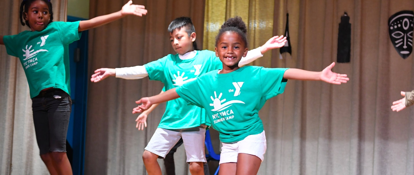 Kids performing on a stage during the West Side YMCA summer day camp.