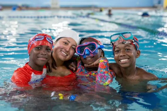 Swimmers pose with their instructor in the pool