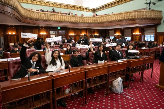 Teens Take the City teens lift their name cards up at City Hall.