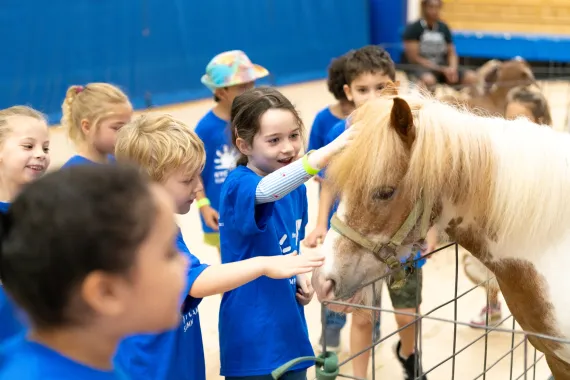 Y campers petting pony at camp