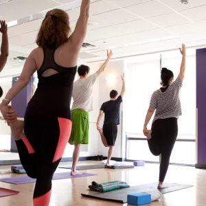A yoga class in a brightly lit studio at the YMCA.