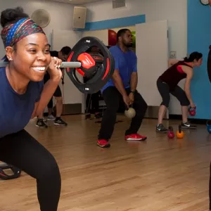 Woman lifting weights in free YMCA group fitness class