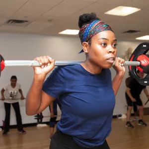 A woman lifting weights in a YMCA group fitness class