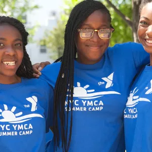 Three day campers smiling at the camera from a YMCA summer camp