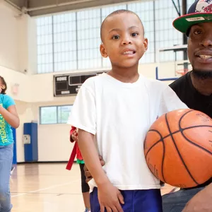 Father and son playing basketball at YMCA in Brooklyn