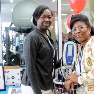 Two staff members with a blood pressure monitor.