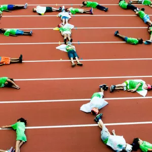 Kids form letters with their bodies on the track at the Prospect Park and Park Slope Armory YMCA summer day camp.