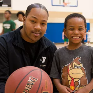 Young boy with basketball instructor at YMCA