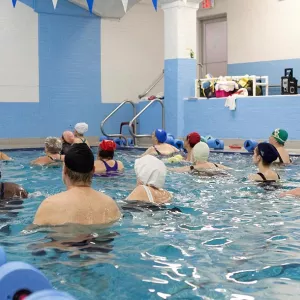 Adults taking water exercise class in the indoor pool at the YMCA in Brooklyn