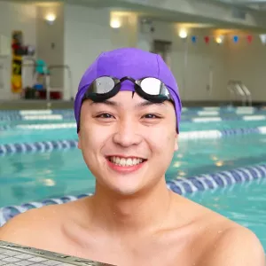 Man smiling at end of lap lane of Vanderbilt YMCA indoor pool