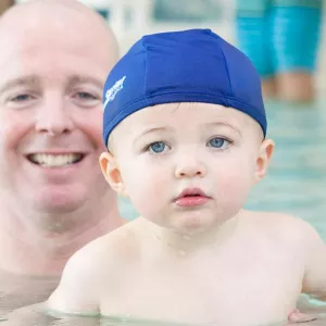 Dad and baby swimming at YMCA indoor pool