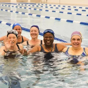 Group of women in water fitness class at YMCA indoor pool