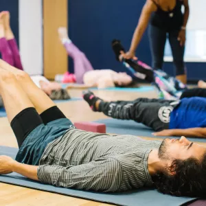 Class practicing yoga on mats at Ridgewood YMCA studio in Queens