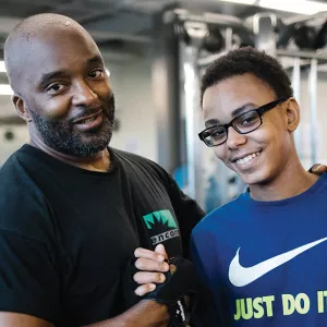 Dad and son lift weights at YMCA