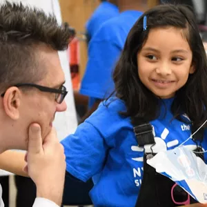 A camper shows her science project to a counselor during STEM camp at the Y.