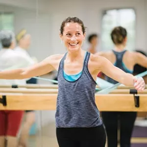 Woman using elastic band in YMCA barre class 