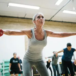 Woman lifting weights in boot camp class