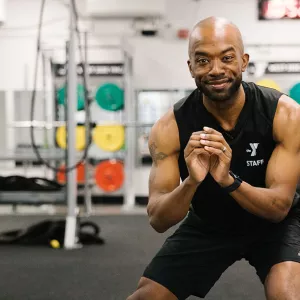 A YMCA instructor works out with no equipment.