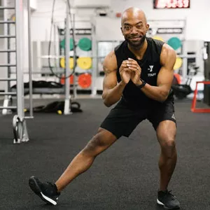 A YMCA instructor works out with no equipment.