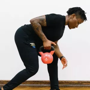 A YMCA instructor works out at home with a kettlebell.