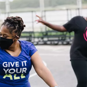 Two women participate in an outdoor Zumba class at the YMCA.