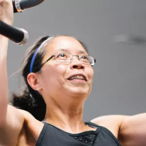 A woman doing a pull up at the gym