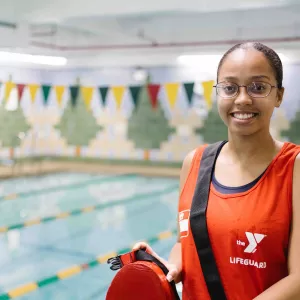 woman lifeguard standing in front of pool