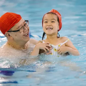 Male adult and girl in pool