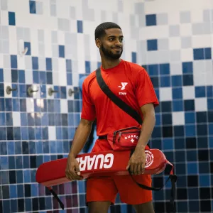 male lifeguard holding flotation device