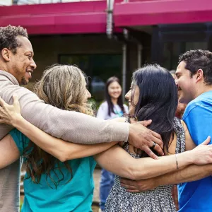 four people hug