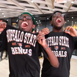 two teens showing off their college tshirts