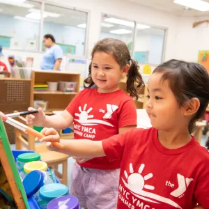 2 girls painting in classroom