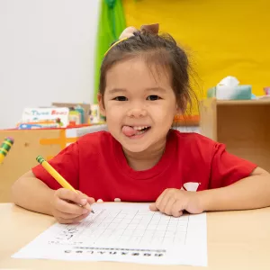 child working on a worksheet in a classroom