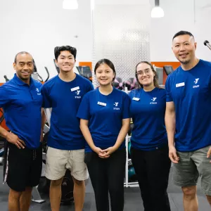 5 staff members smile in gym