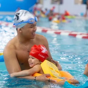 instructor holding child in pool