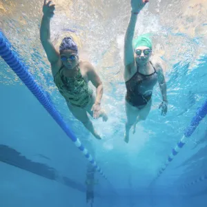 2 women swim underwater