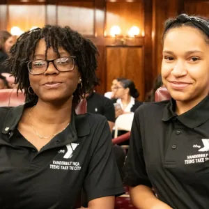 Two teen girls from the Teens Take the City smiling during a moment at the culminating event at NYC City Hall