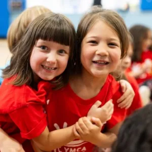 2 girls hug and smile