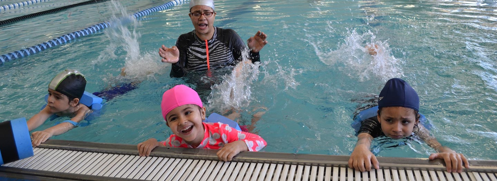 Kids in adaptive swim class for students with special needs at indoor swimming pool