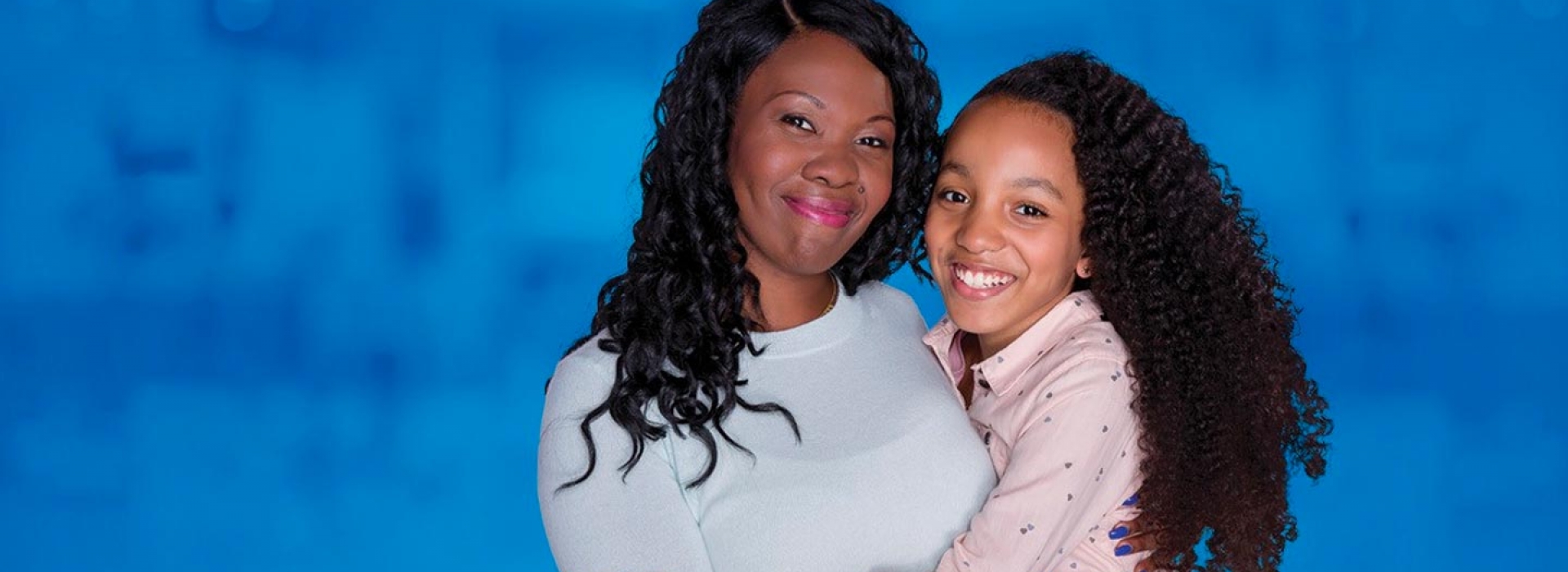 A mother and her daughter smile at the camera