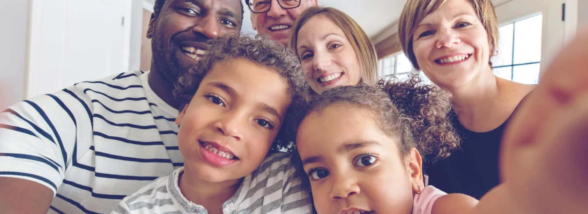 A multi-racial, multi-generational family smiling.