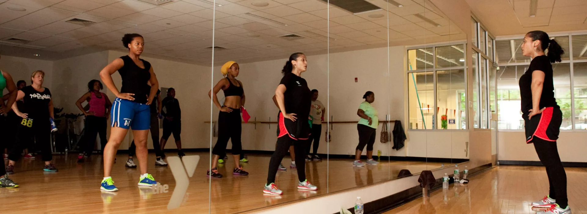 A group fitness class in a mirrored fitness studio at the Coney Island YMCA.