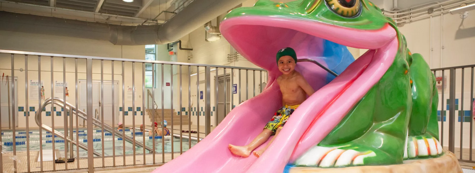 A child slides down a frog water slide at the Coney Island YMCA.